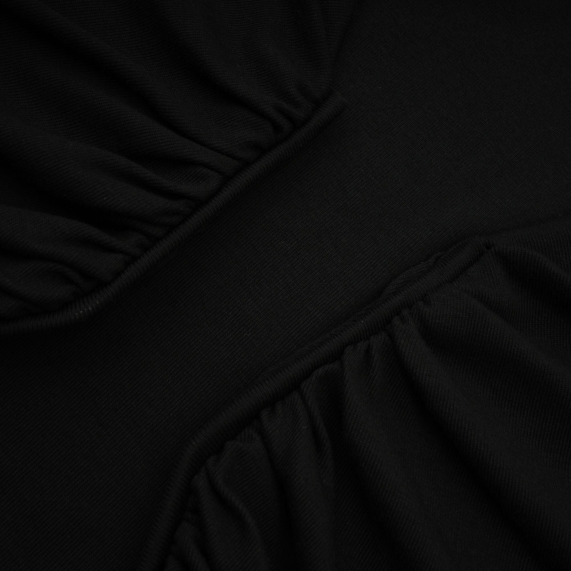 Anaïs svart topp med öppen framsida och rynkad passform