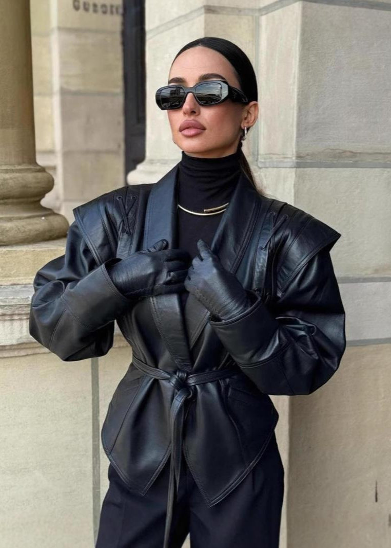 Madée | Svart damkavaj i läderlook med rosettbälte och axeldetaljer