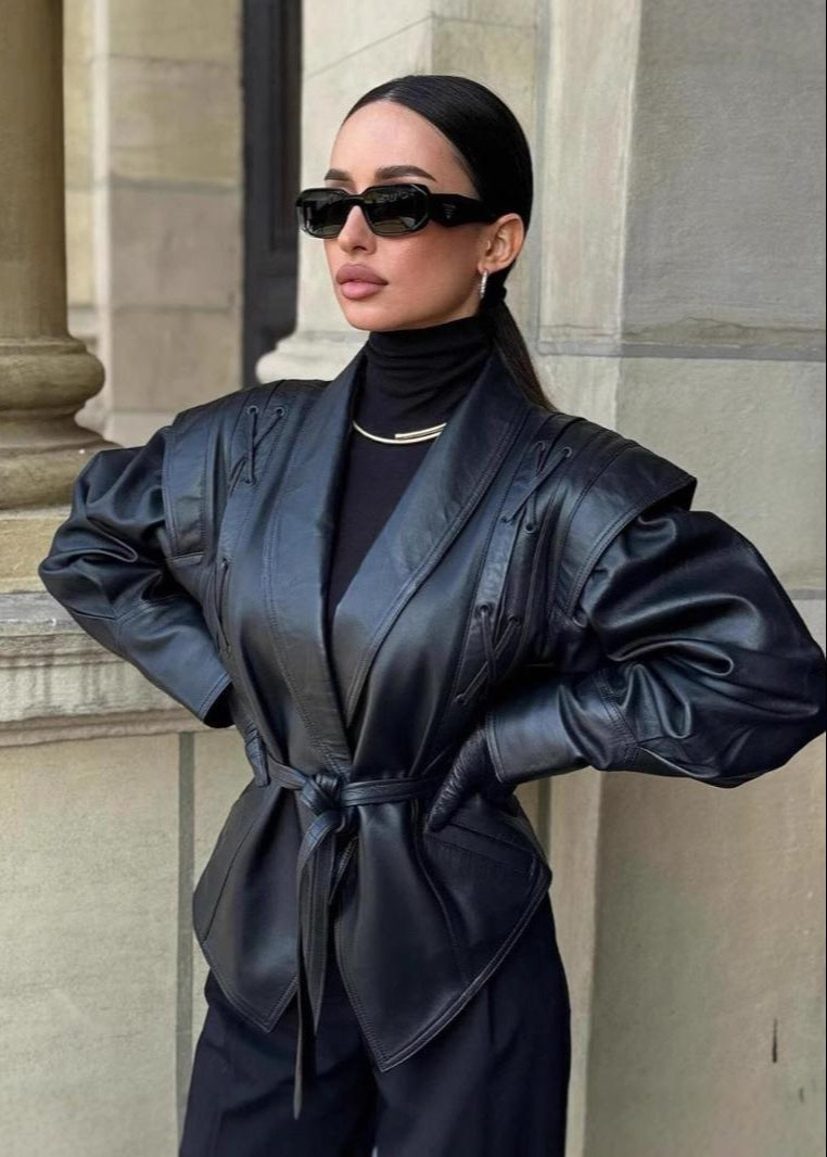 Madée | Svart damkavaj i läderlook med rosettbälte och axeldetaljer